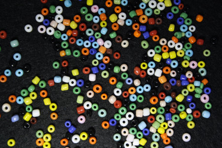 Colorful beads on a black felt background. Space for text.の写真素材