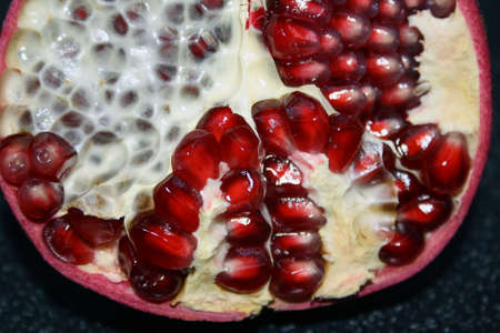 Red ripe pomegranate on a black background. Space for text.の写真素材