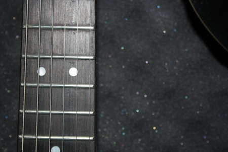 Guitar strings, light wood guitar body. Space for text.