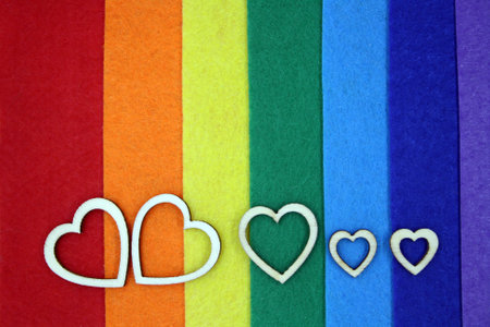 Wooden hearts on multi-colored felt. Space for text.の写真素材