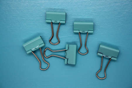 Paper clips on a blue background. Space for text.