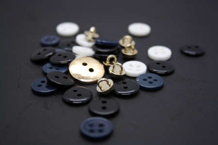 Blue, white and black buttons on black background. Space for text.