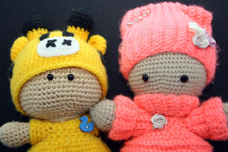 A doll made of yarn on a black background. Space for text.の写真素材