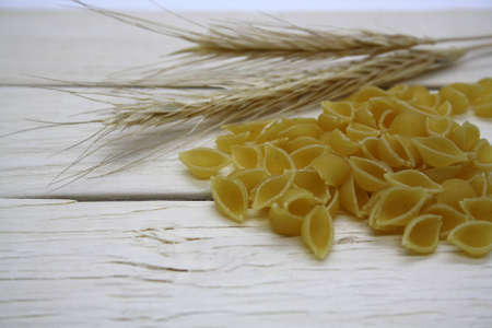 Dry wheat pasta on a wooden background. Space for text.の写真素材