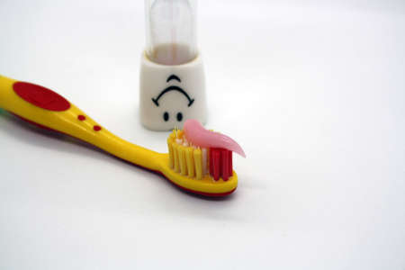 Children's toothbrush with paste and an hourglass. Space for text.の写真素材