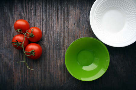 Red tomatoes on a branch on a wooden background. Space for text.の写真素材