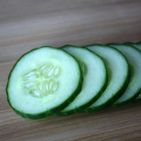 Cucumbers on a wooden board. Culinary background. Space for text.の写真素材
