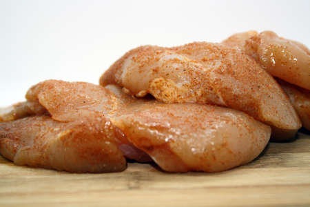 Chicken fillet pieces on a wooden board. Space for text.の写真素材