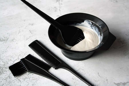 Professional hair dresser tools with copy space. Brush, comb, hair dye in a bowl.