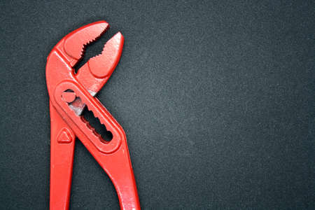 Red adjustable wrench. Tool for tightening nuts on a black background.の写真素材