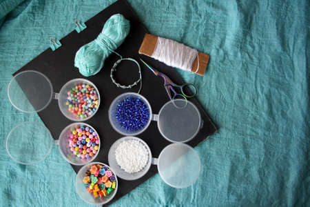 Materials for making a bracelet from beads and threads. Space for text.
