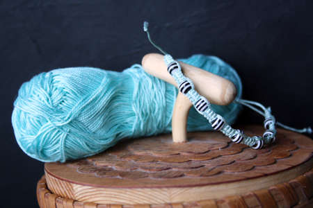 A bracelet made of beads and threads on a birch bark casket. Space for text.