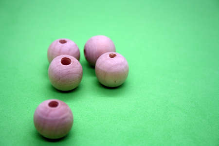 Five wooden beads on a green background. Space for text.の写真素材