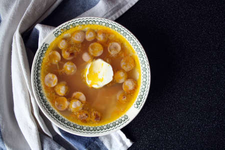Potato and sausage soup. Quick dish. Black background. Space for text.の写真素材