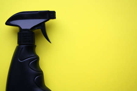 Black spray isolated on a yellow background. Space for text.の写真素材