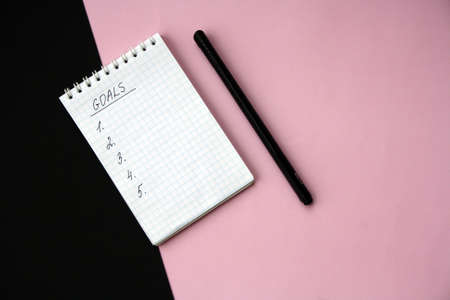 2022 notebook mockup on pink background. New Year. Plans, goals for 2022, space for text in a...