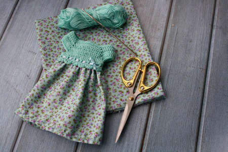 Crochet dress for a doll made of cotton yarn and textile. Home needlework made of thread. Knitting...