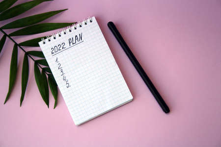 2022 notebook mockup on pink background. New Year. Plans, goals for 2022, space for text in a notebook.の写真素材