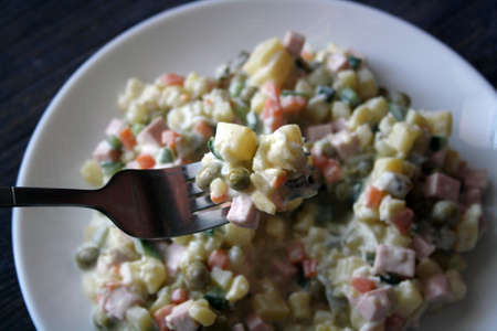 Salad of potatoes with sausage, peas, carrots and cucumbers. Olivier. Space for text.の写真素材
