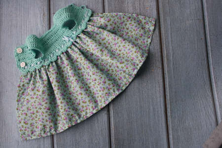 Crochet dress for a doll made of cotton yarn and textile. Home needlework made of thread. Knitting for toys.の写真素材