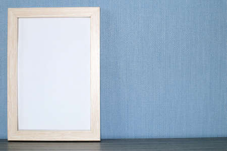 Mockup frame or poster on a blue wall background. Space for text.