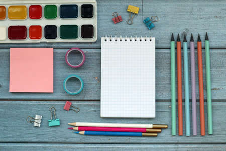 Office scool supplies on blue wood desk. Top view.