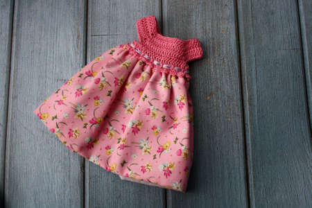Crochet dress for a doll made of cotton yarn and textile. Home needlework made of thread. Knitting for toys.の写真素材