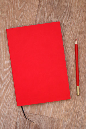 Mock up book blank red leather cover for magazine, booklet, brochure, diary, business portfolio mock-up design template on wooden background. Flat lay, top viewの写真素材