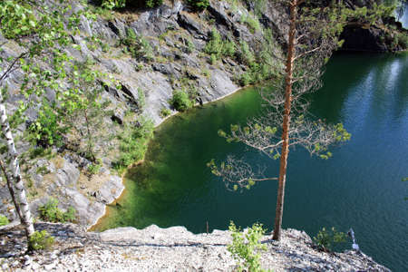 The amazing nature of the Karelian Isthmus. Forests of Karelia. View from a steep cliff to the green water of the lakeの写真素材