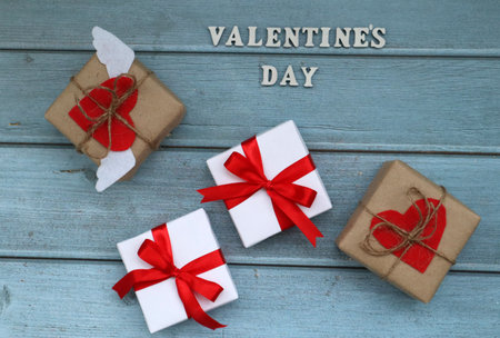 <p>Craft and white gift boxes with red ribbon on blue wooden background. For celebrate. Valentines day concept. top view</p>の写真素材