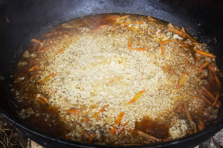 Cooking pilaf in a large cauldron. Traditional national dish in Central Asia.の写真素材