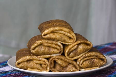Stack of stuffed pancakes on a plate.の写真素材