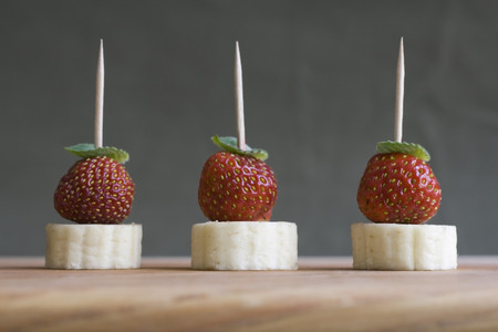 Fruit canape - banana and strawberry with mint leafの写真素材