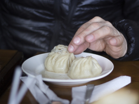 Eating with  hands poses - traditional Buryat food.の写真素材