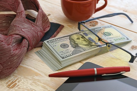a bundle of money and other items on the tableの写真素材