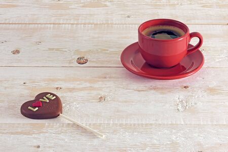 Coffee and chocolate heart on the tableの写真素材