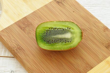 Half kiwi on a chopping board close upの写真素材