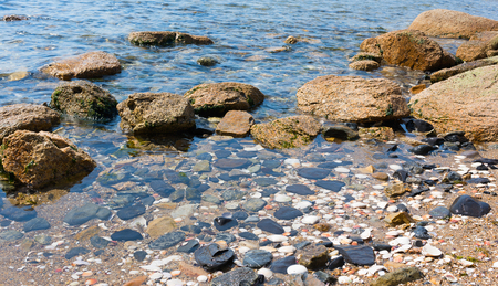 Sand and rocks on the shore of the Pacific Ocean in the summerの写真素材
