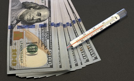 dollars and thermometer on a dark backgroundの写真素材