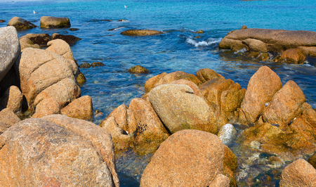 Sand and rocks on the shore of the Pacific Ocean in the summerの写真素材