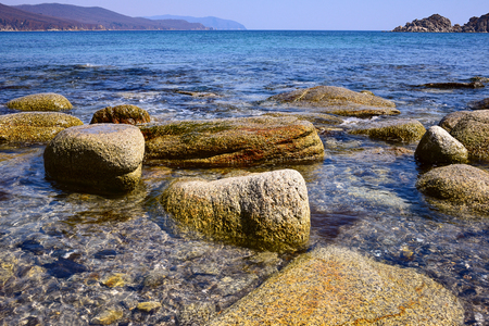 Sand and rocks on the shore of the Pacific Ocean in the summerの写真素材