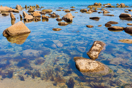 Sand and rocks on the shore of the Pacific Ocean in the summerの写真素材