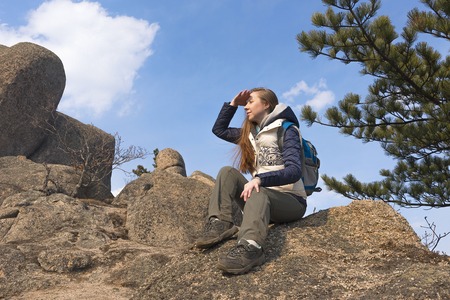 girl sitting on a rock at the top of the mountainの写真素材