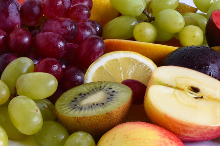 Grape, apple, kiwi and other fruits closeup. Fruit slicesの写真素材