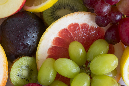 Grape, apple, kiwi and other fruits closeup. Fruit slicesの写真素材