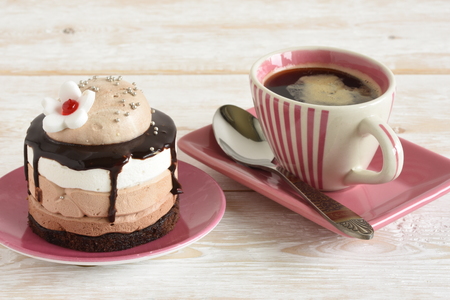 Cup of hot coffee and cake on the table close-upの写真素材