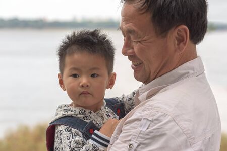 Harbin, Heilongjiang, China - September 2018: Portrait of Asian boy and grandfather. Grandfather...