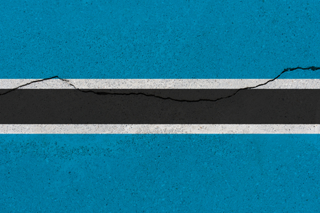 Botswana flag on concrete wall with crack. Patriotic grunge background. National flag of Botswanaの写真素材
