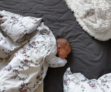 Newborn baby boy sleeping in bed. Overhead view of cute baby