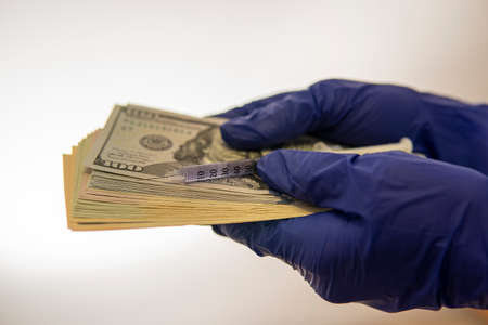 hands in medical gloves keep money on which the syringe lies .. high qualityの写真素材